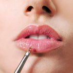 Lip gloss is applied to enhance lips