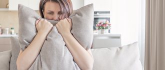 женщина прячет лицо за подушкой